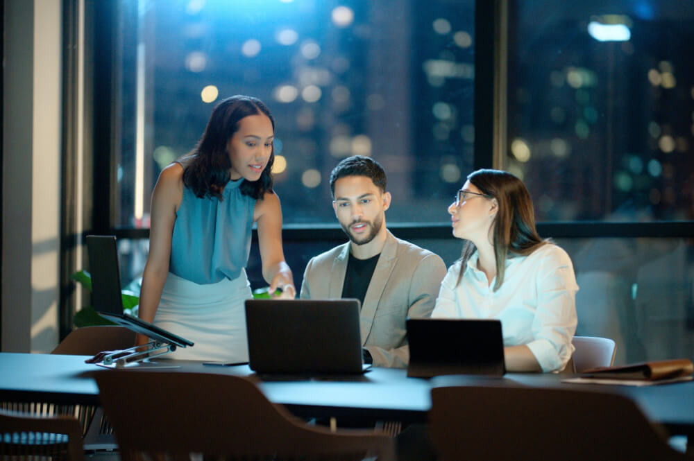 A VP is staying late to meet with her team members to coach them through a challenging project. Skill grows fastest in environments where peers lift each other up.