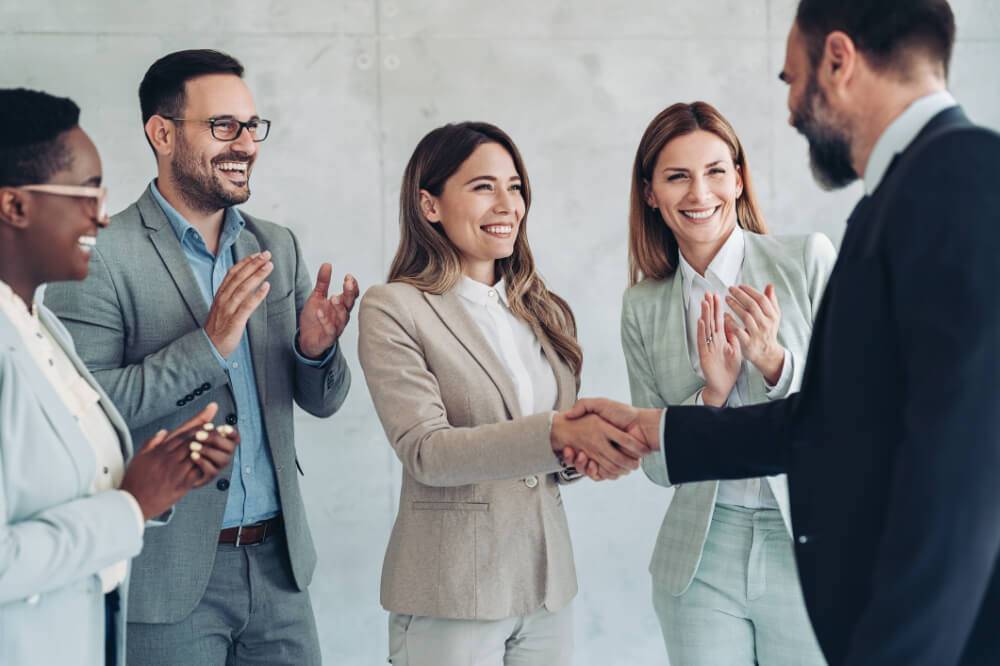 An executive is sharing positive feedback with his team while also addressing sticky points. Honest communication balances encouragement with accountability.