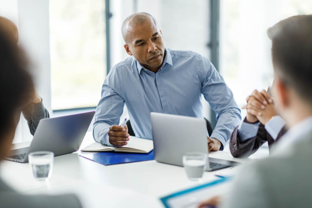 A director is sharing a tough decision with his team. Transparency and integrity strengthen trust, even in challenging conversations.