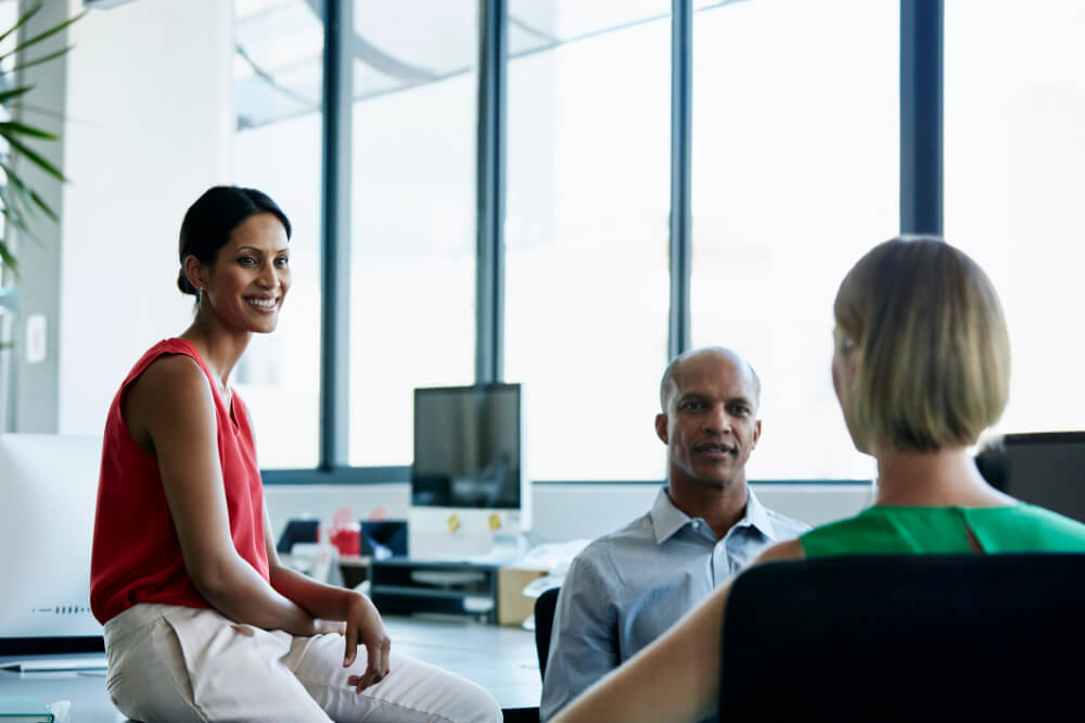 A newly promoted leader is listening to the viewpoints of her team members. Listening first isn’t just respectful—it’s transformational for leadership.