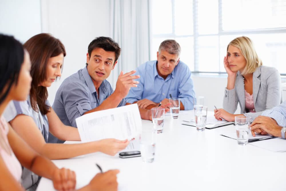 A team of executives is discussing how various projects tie into larger objectives. Aligning roles with goals ensures every project supports your broader vision.