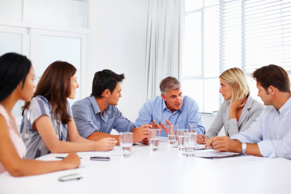 A team of executives are addressing leadership challenges. Delegate with clarity, and you’ll find managing complexity becomes far simpler.