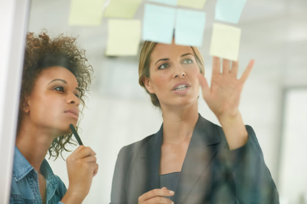 Two team leaders are assigning roles. Assign ownership thoughtfully—balance accountability and workload to keep things running smoothly.